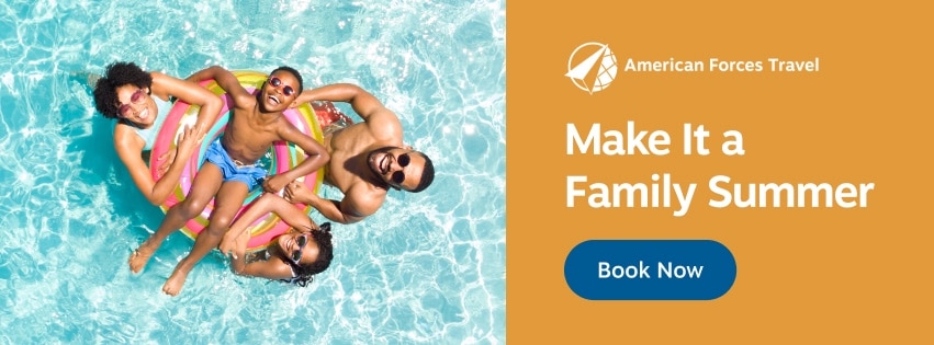 American Forces Travel Summer Campaign 851x315 Promotional graphic for American Forces Travel showing a small sandy beach cove with turquoise water, rocky cliffs, and two people lying on the sand. Text on the graphic reads “American Forces Travel. Time to recharge this spring. Book Now.”